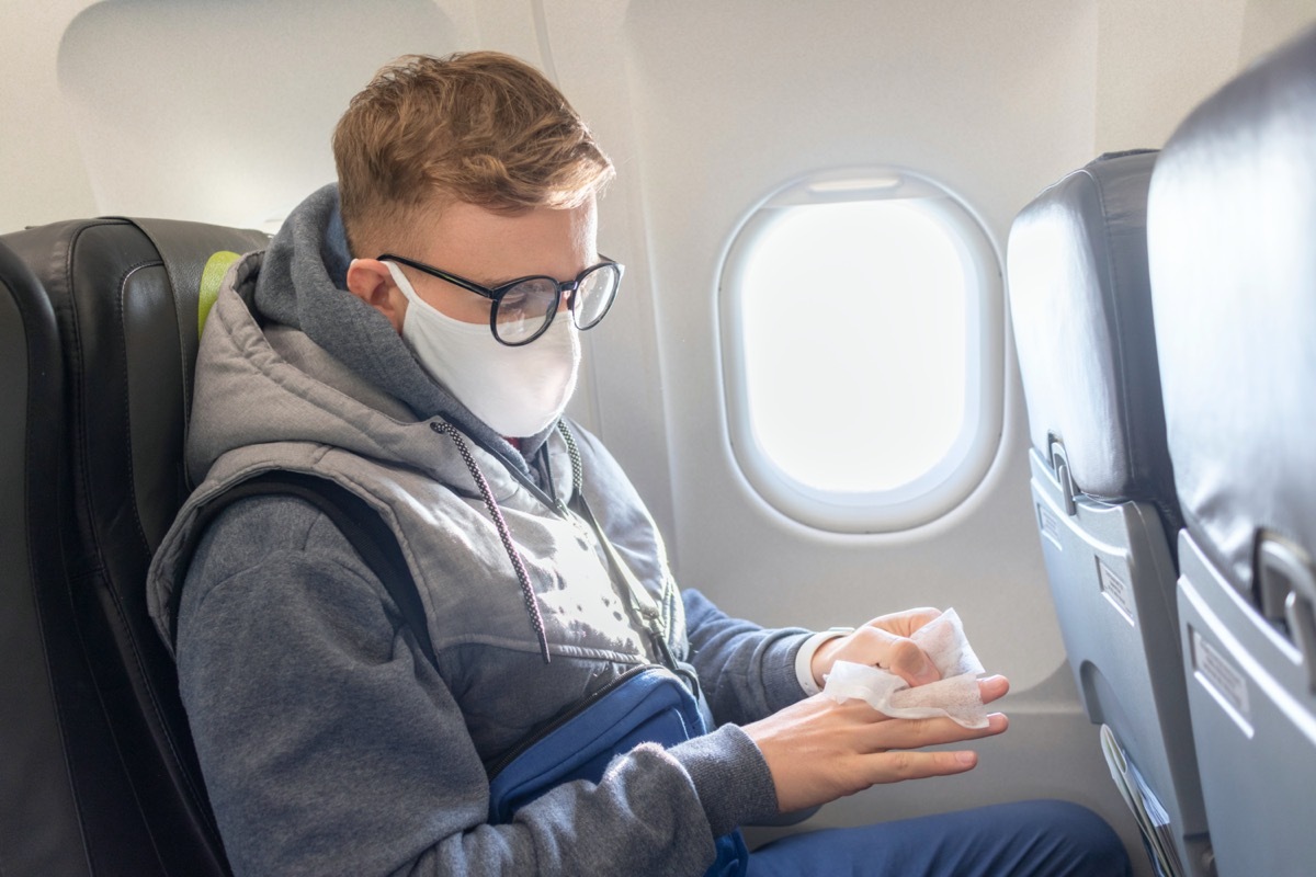 man wears a medical mask and wipes his hands with disinfectant