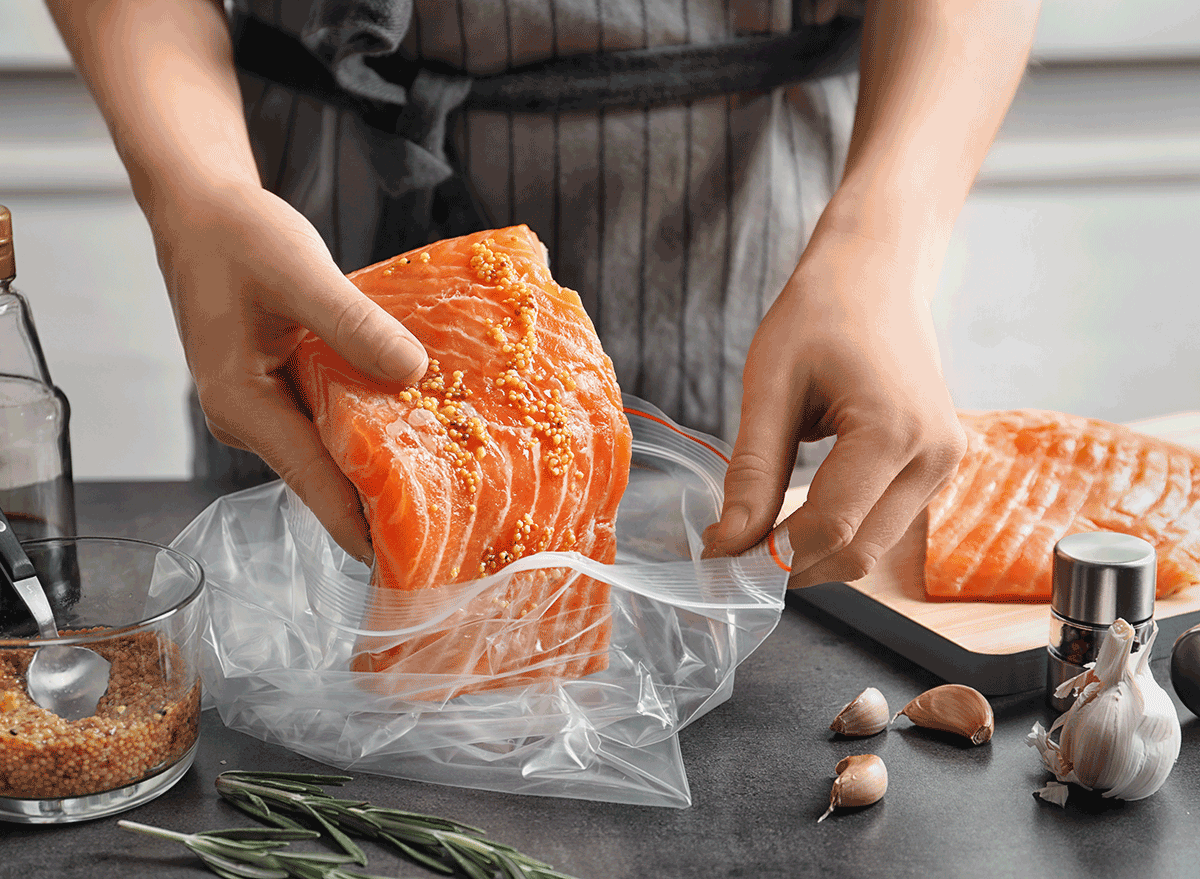 woman preparing salmon before cooking