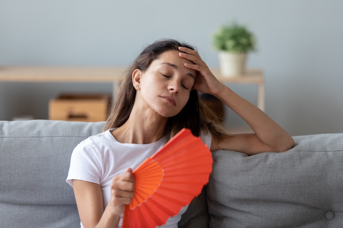 woman fanning herself on couch