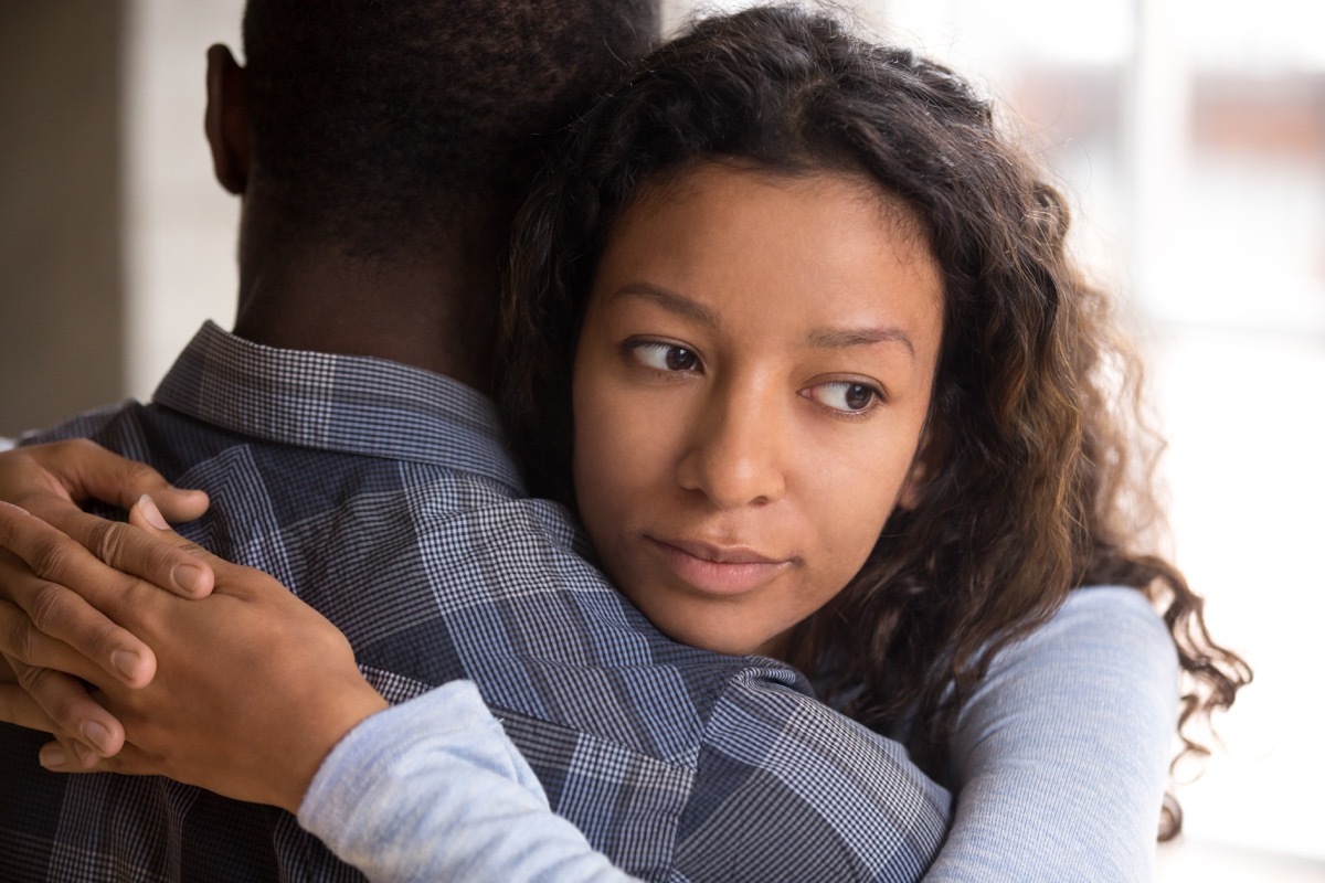 couple hugging partner with a worried face