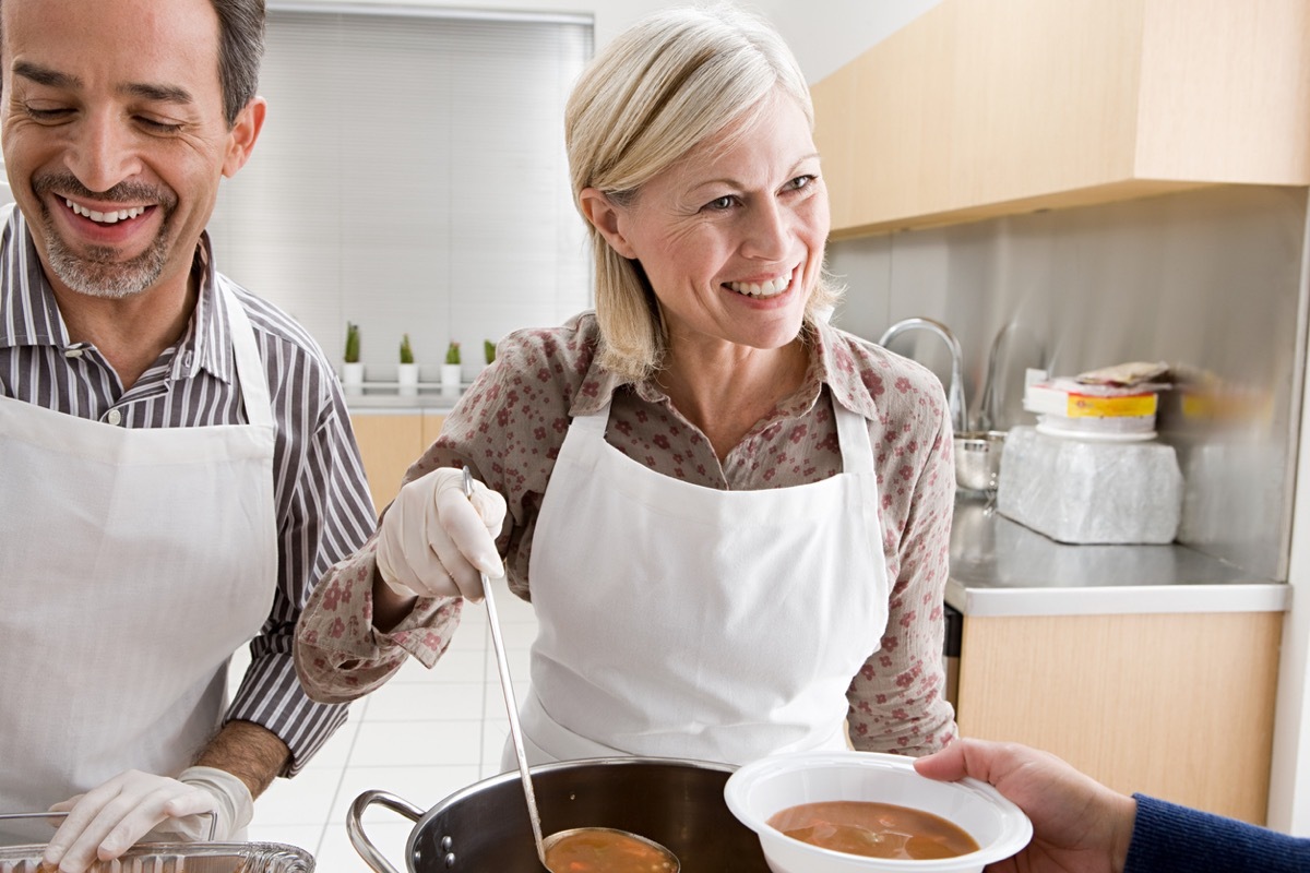 middle aged white couple volunteering at a soup kitchen