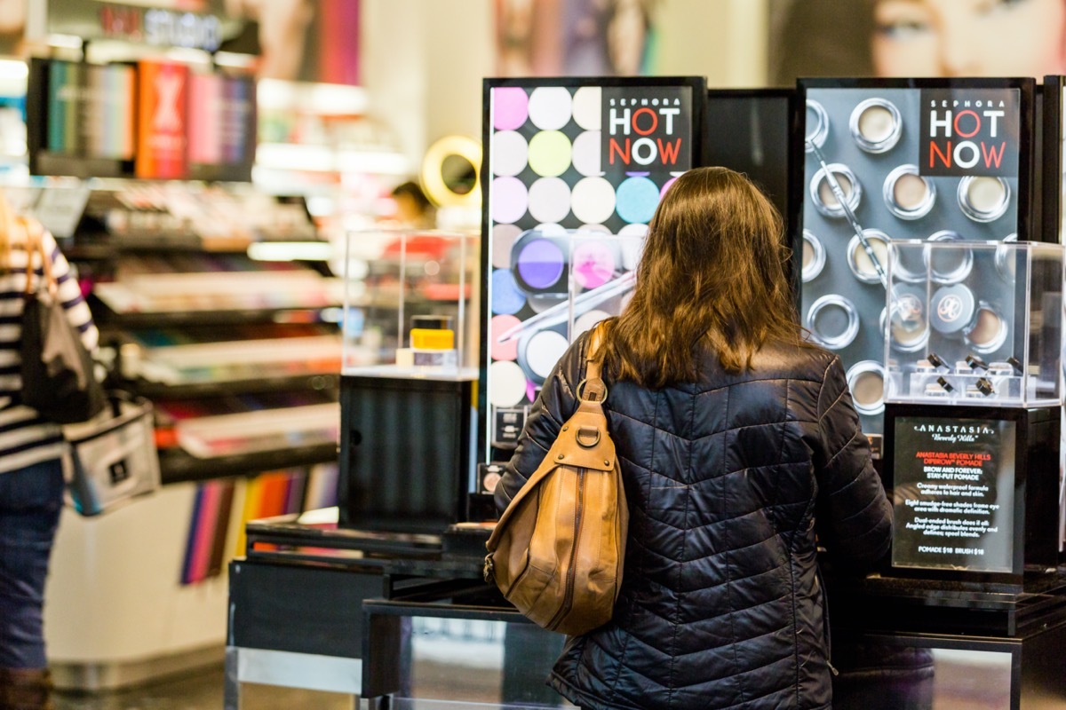 woman shopping makeup rack at sephora