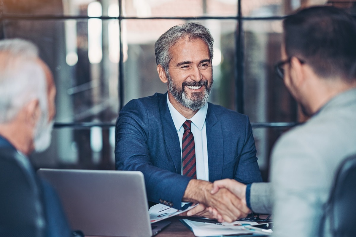 male employees shaking hands in a conference room