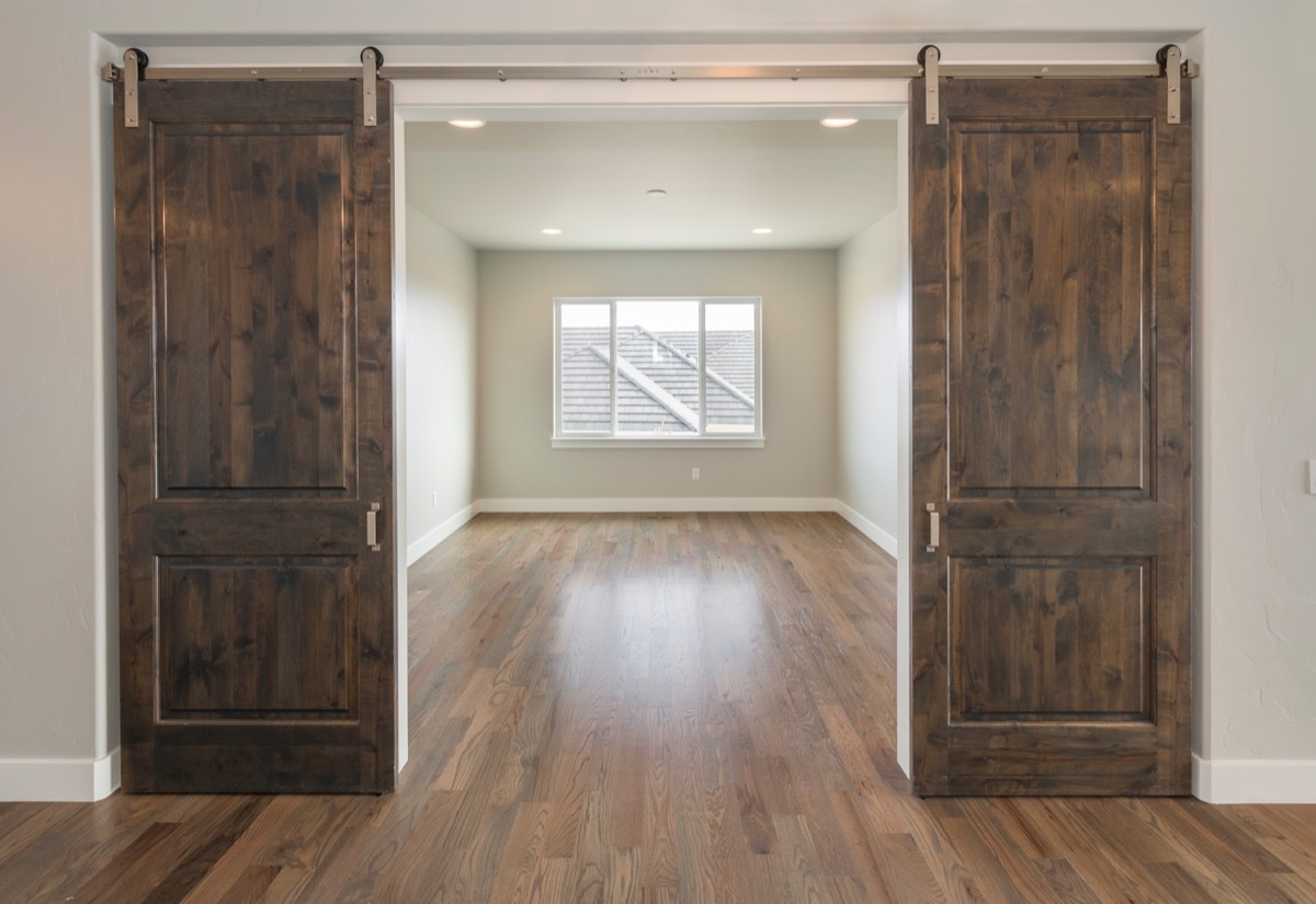 barn doors in home opening onto empty room with window