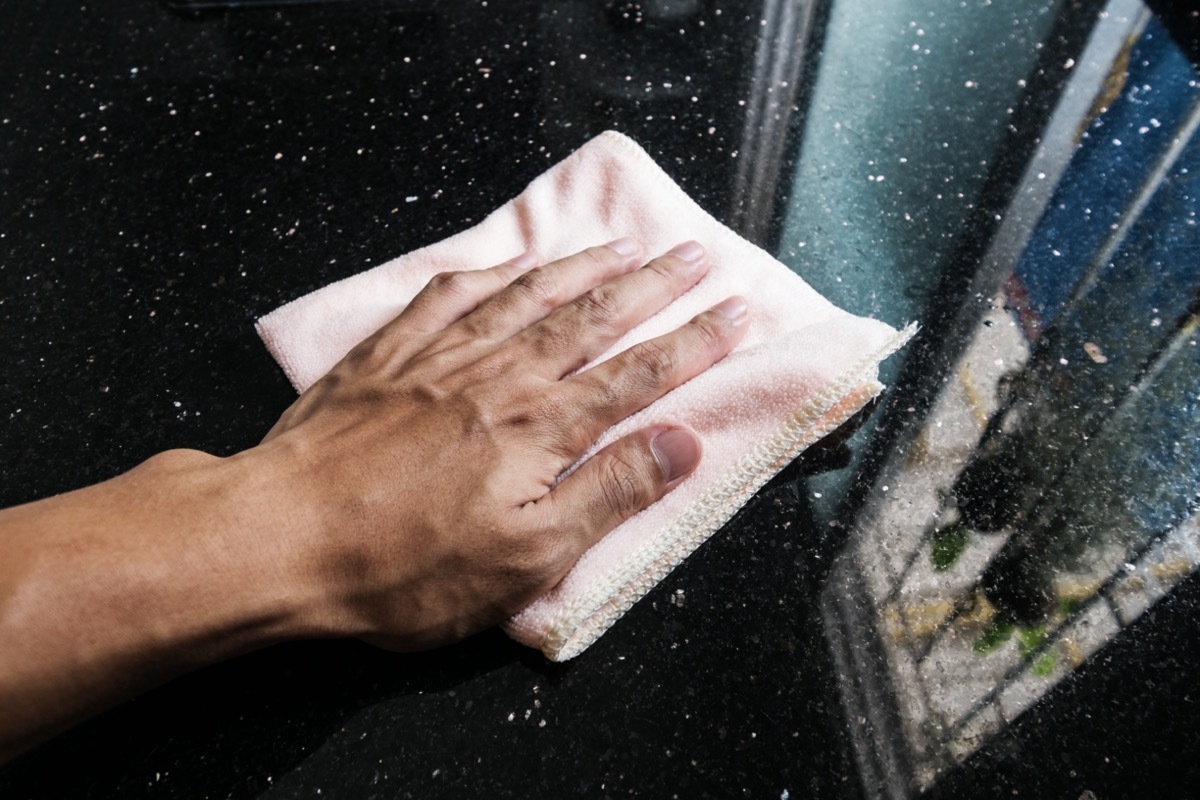 white hand cleaning black marble