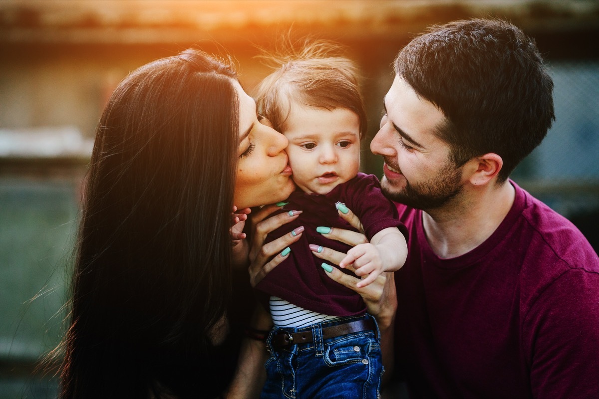 a young child being held by mom and dad