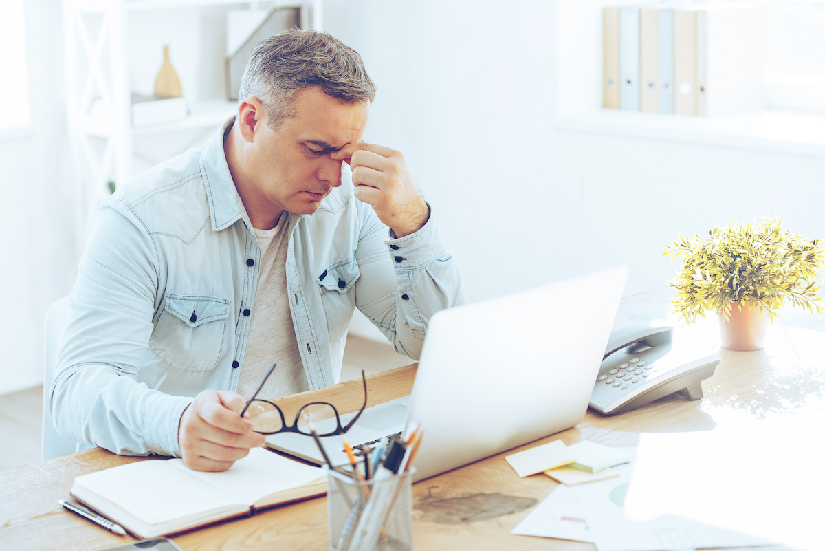 Tired man with gray hair sitting at desk