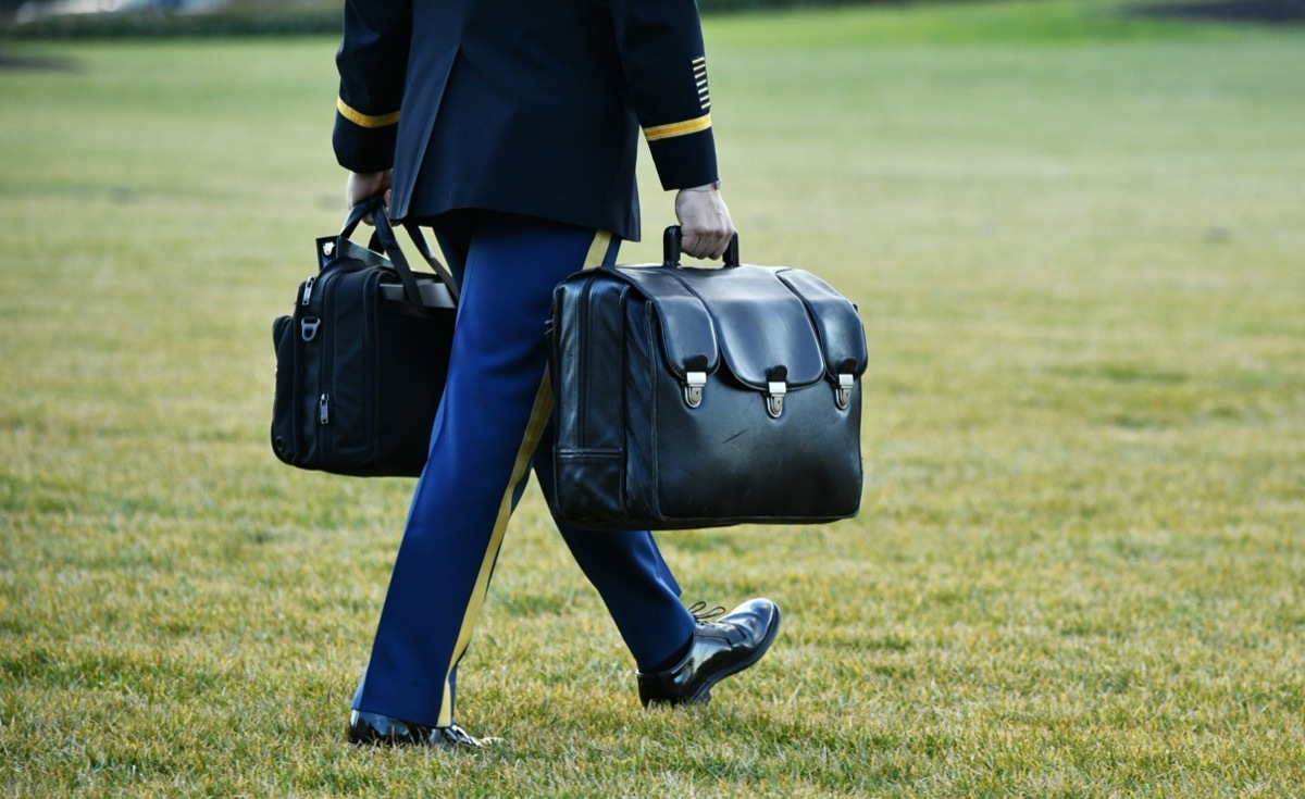 a uniformed member of the armed services brings the nuclear football to marine one