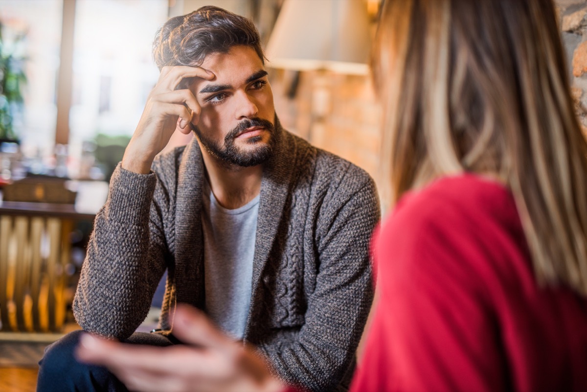 man looking annoyed while listening to woman complain