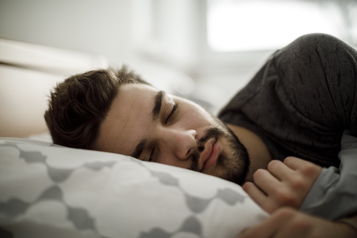 Young man sleeping in bed