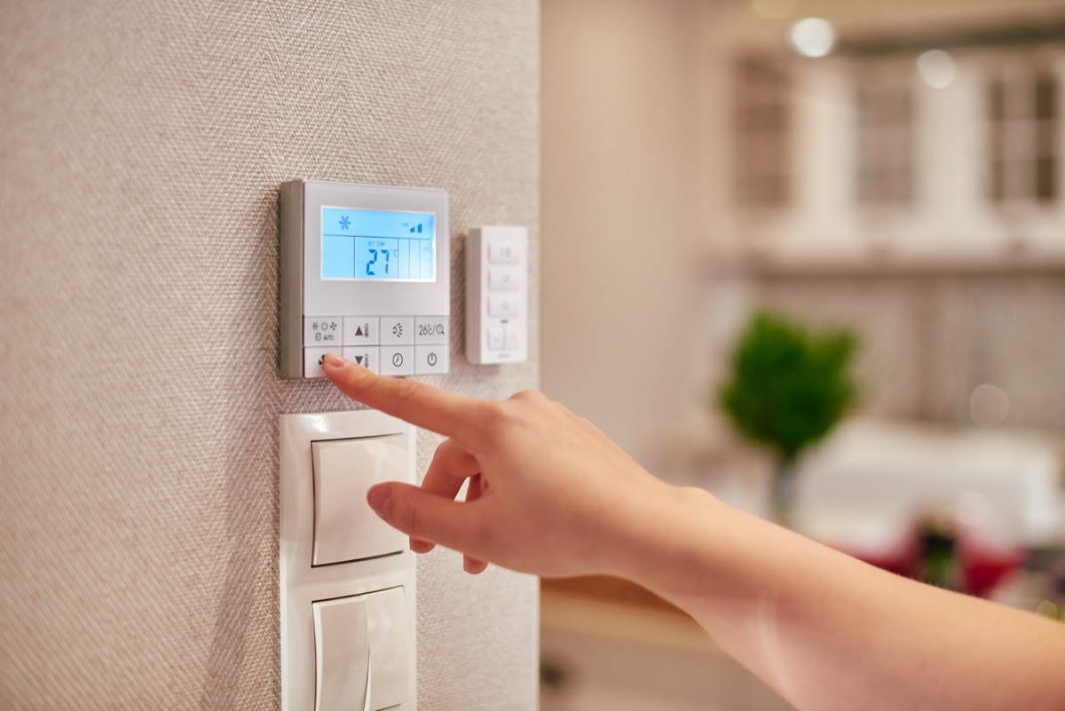 white hand programming thermostat