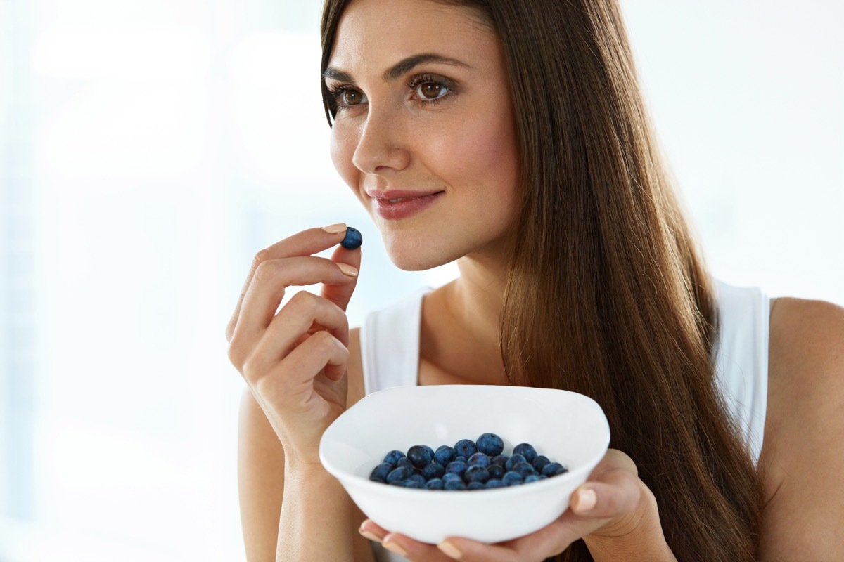 Woman snacking on some blueberries