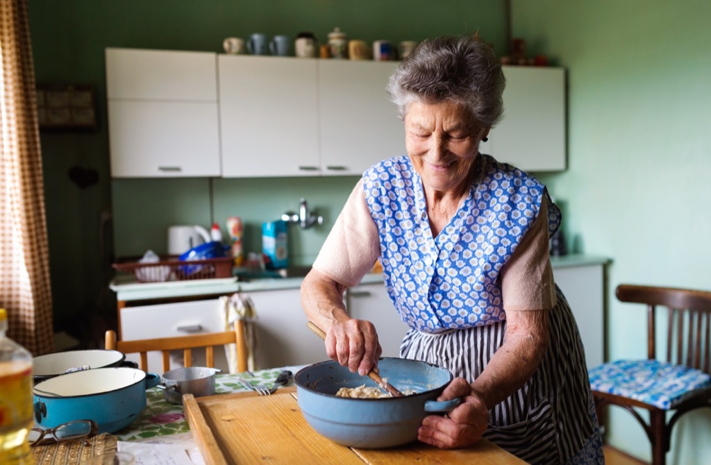 Old woman, grandma in the kitchen cooking