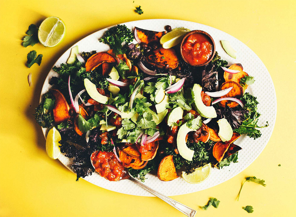 kale nachos topped with cilantro and avocado