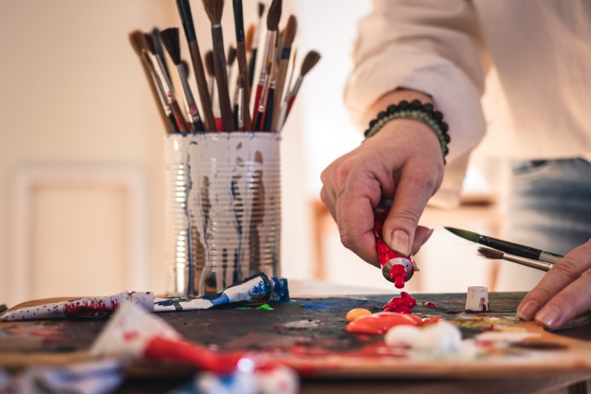 artist using paint and paintbrushes