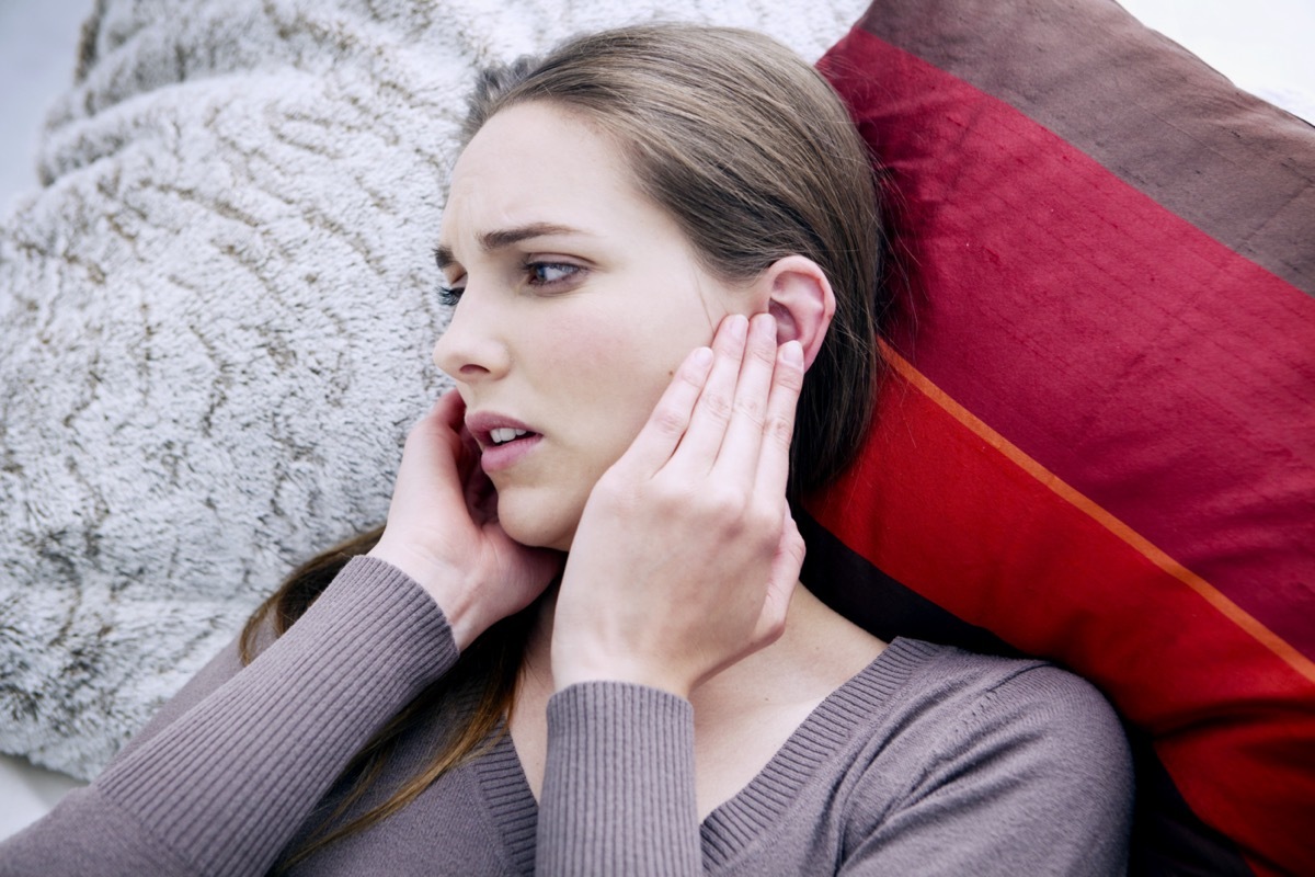 Woman touching her ears.