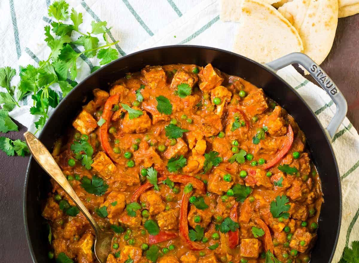 paneer tikka masala recipe with tofu on a skillet with bread and herbs