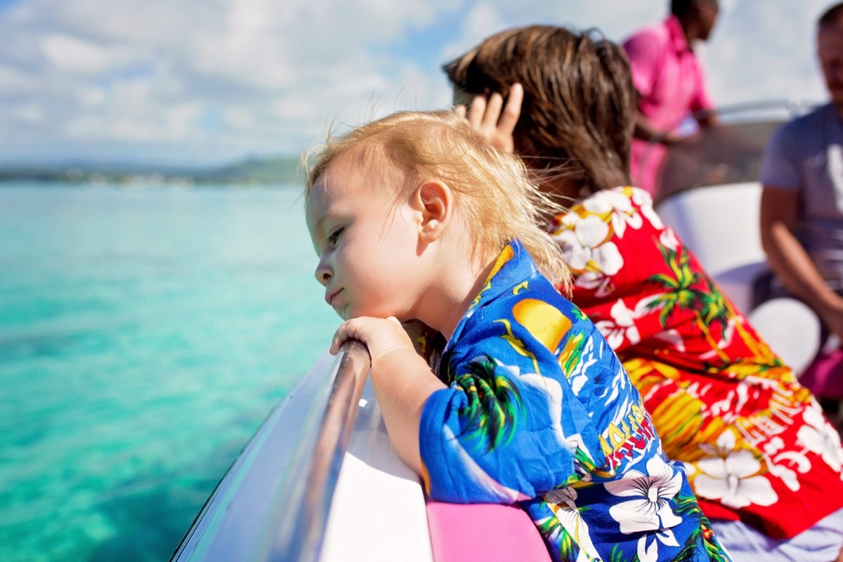 little kids wearing Hawaiian shirts on a boat