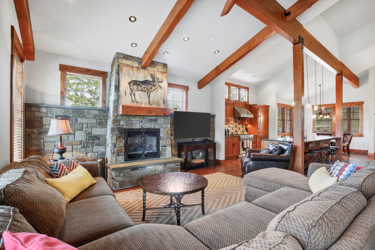 living room with gray couches and wood beamed ceiling