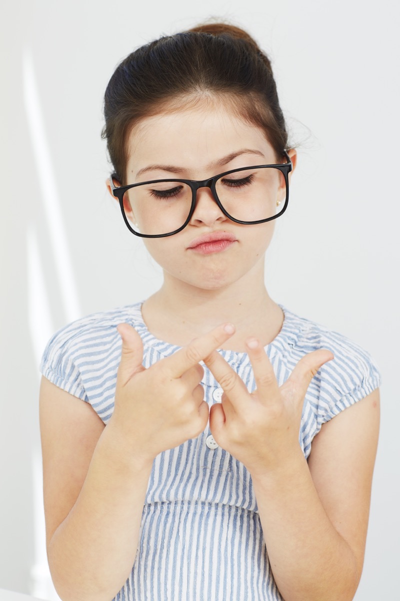 Little girl counting on her fingers wearing glasses