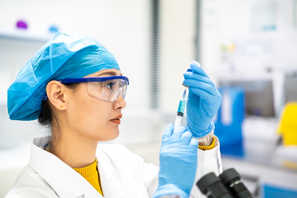 woman scientist uses a syringe in a lab