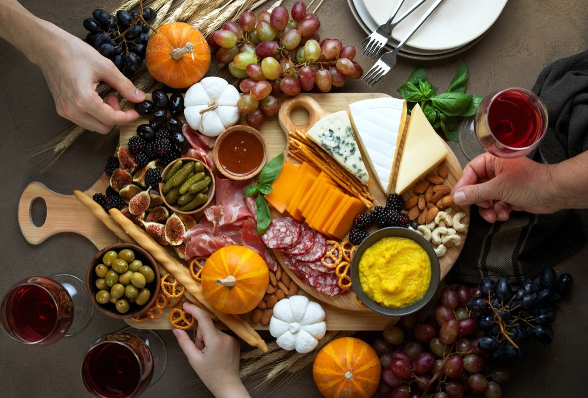 people touching charcuterie plate