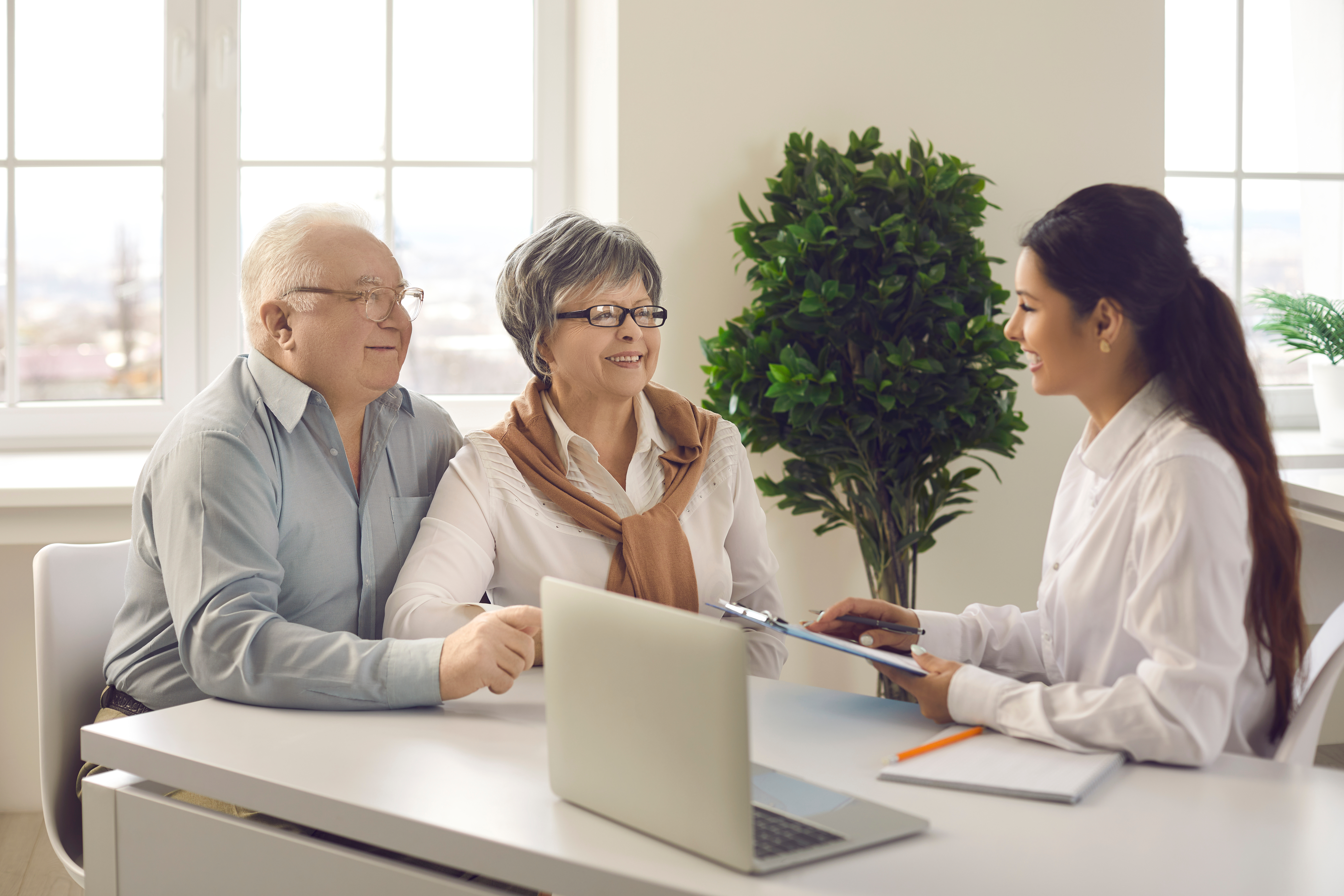 Two retirees talk to a tax consultant in a well lit room.