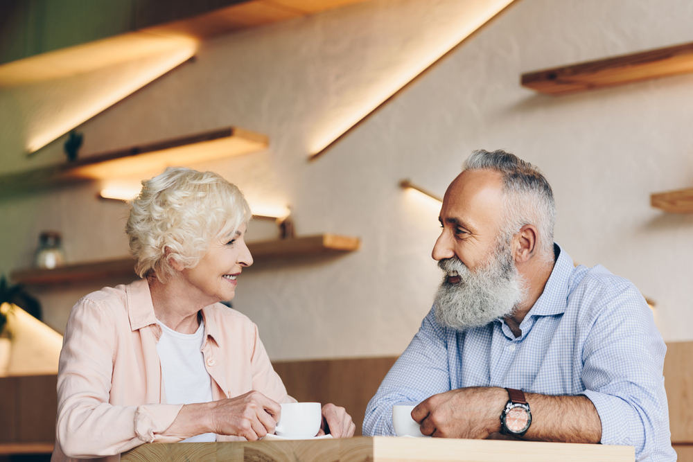 A senior man and woman having a conversation in a cafe