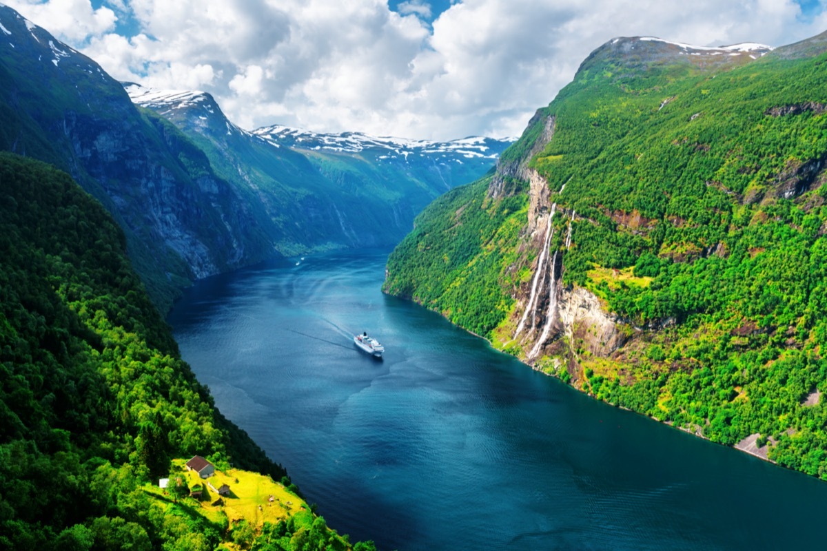 a ship cruises through a fjord in norway