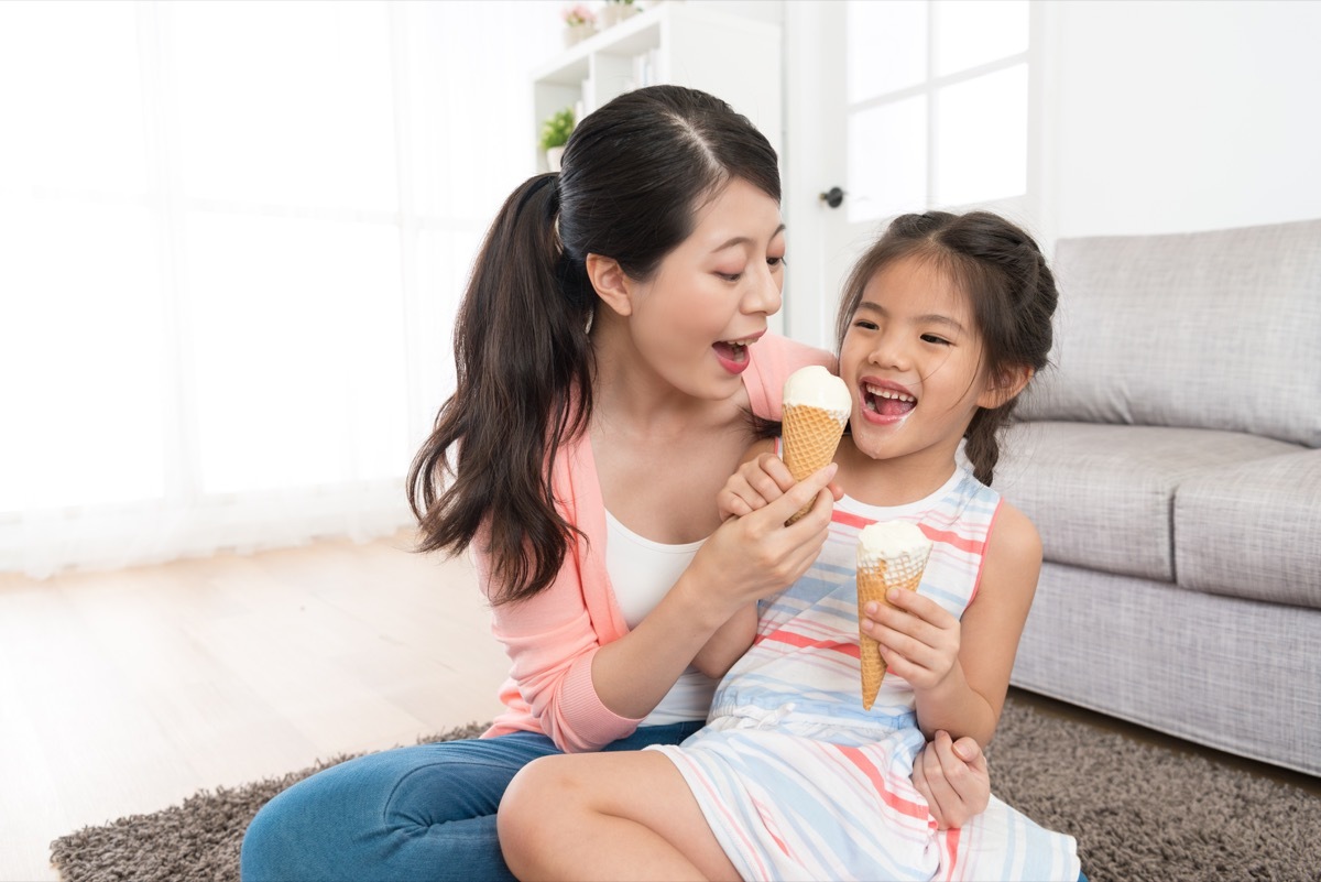 asian mom eating ice cream with young daughter