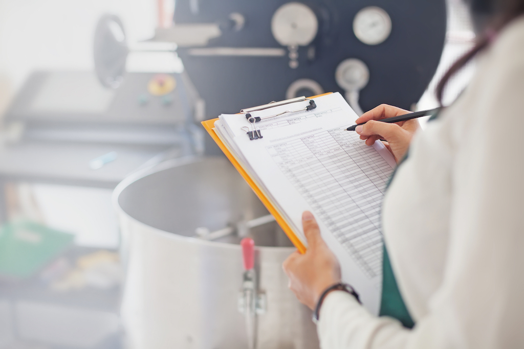 woman with a clipboard taking notes in a kitchen