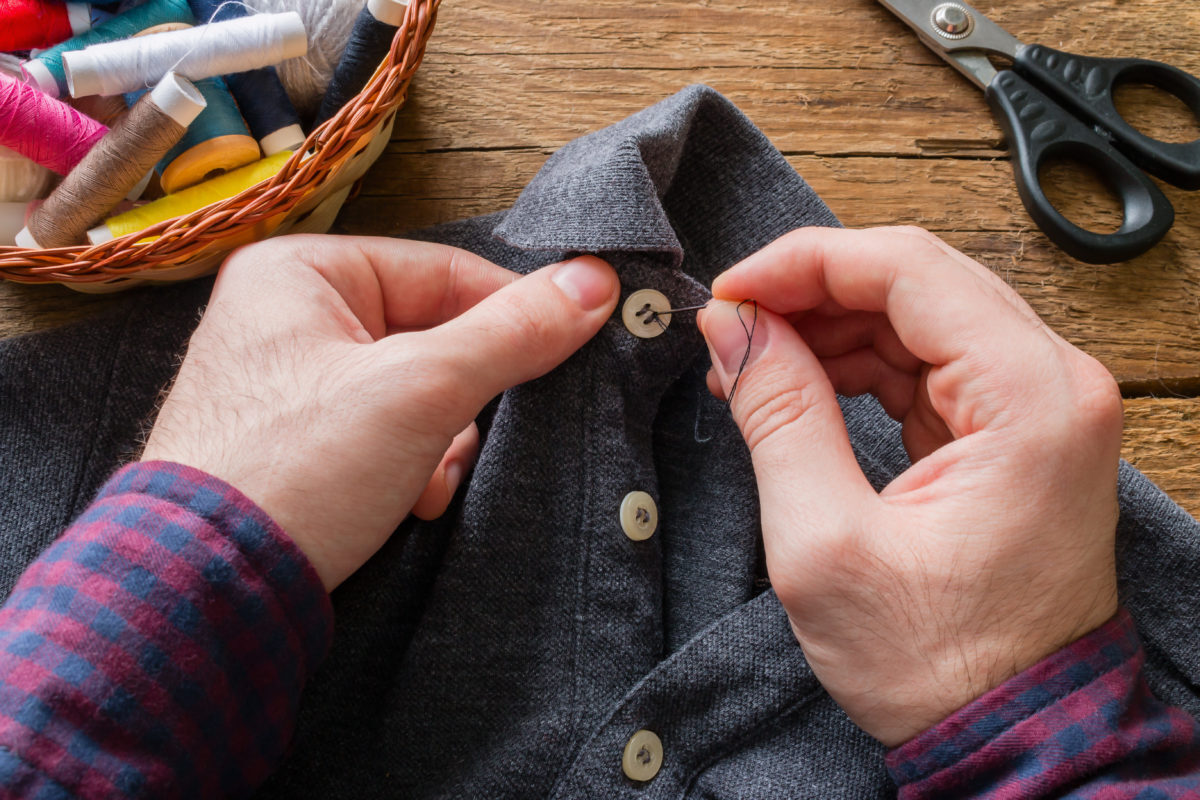 Man fixing shirt button